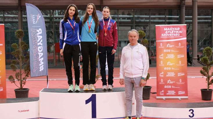 Enyedi Lili Nyíregyházán, a bajnoki dobogó tetején, edzője, László István a dobogó mellett.